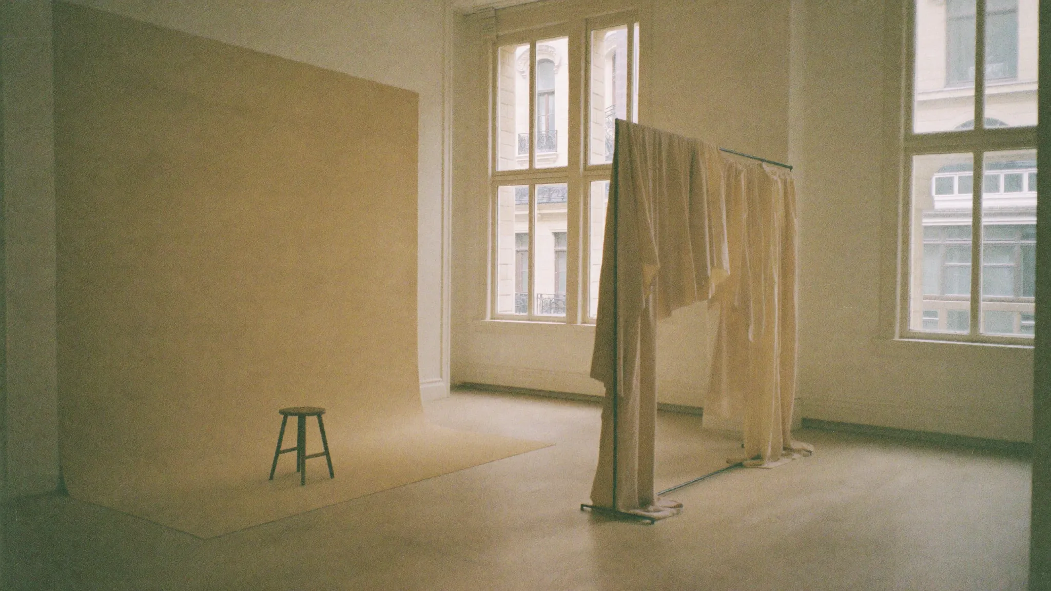 A serene, sunlit atelier interior in warm ivory tones